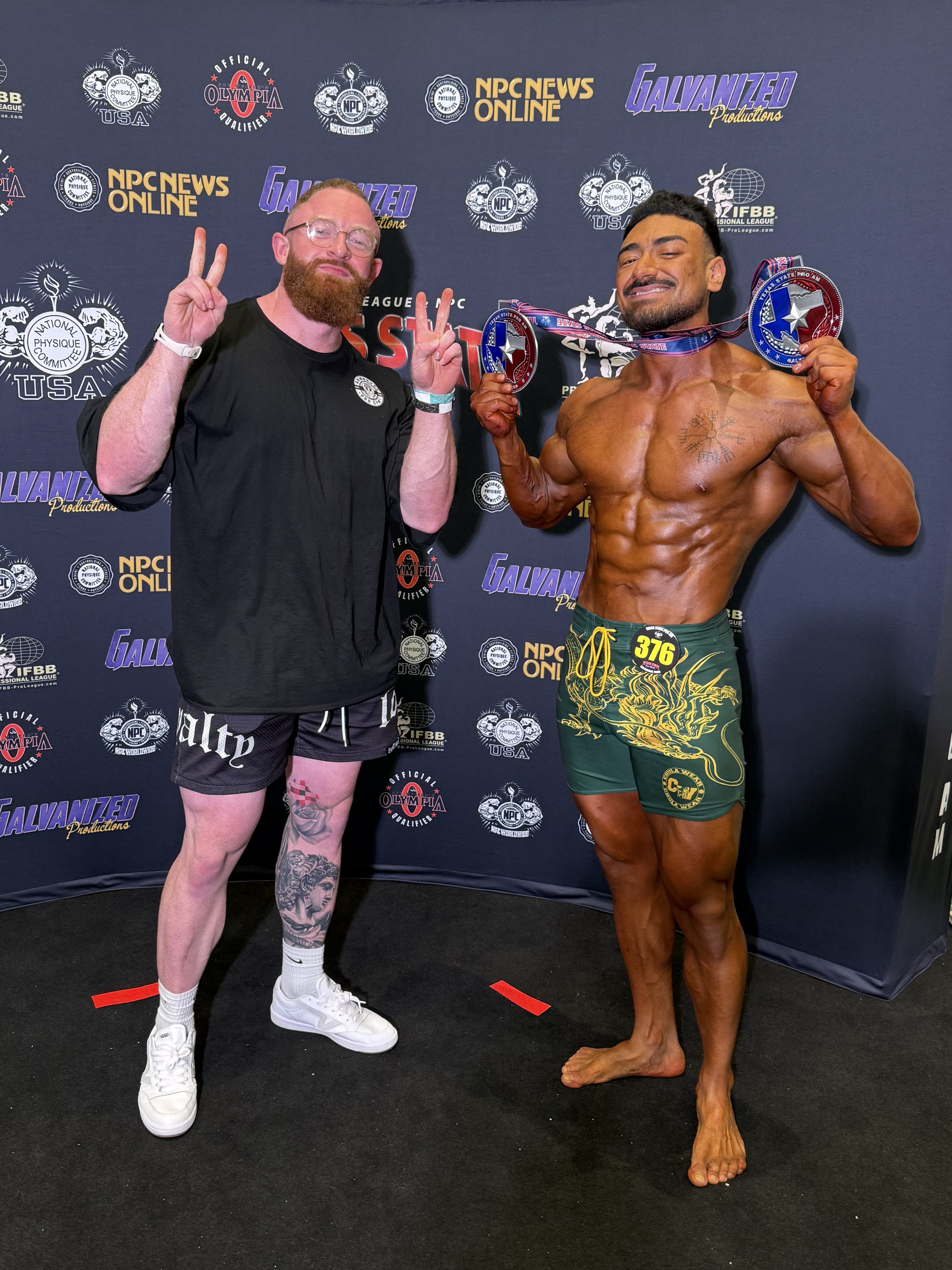 Personal Trainer Marlin Foy stands by a client competing at a bodybuilding competition