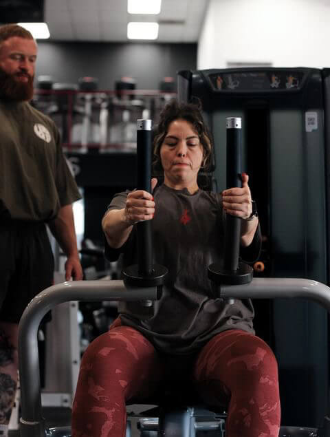 Personal Trainer Marlin Foy guides a client through a chest workout at Iron Forge Gym in Austin, TX