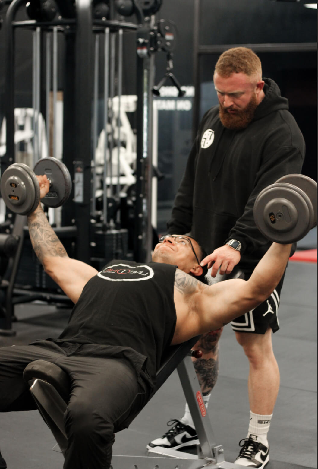 Personal Trainer Marlin Foy guides a client through a chest workout at Iron Forge Gym in Austin, TX